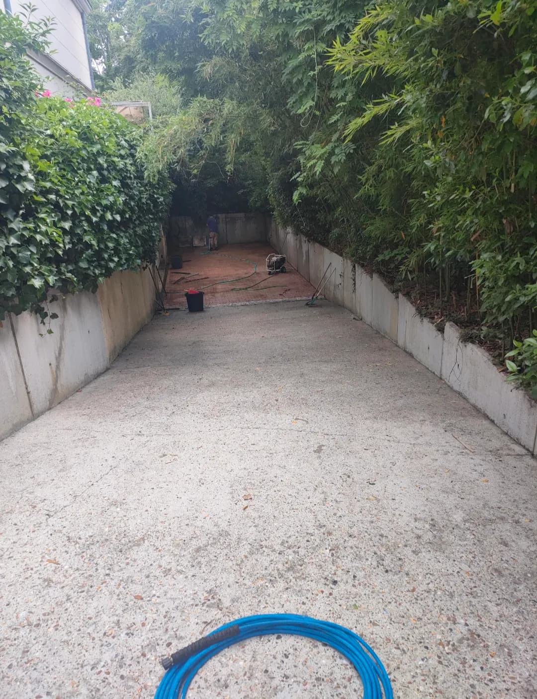 Rampe de garage en béton propre et claire entre deux murs de soutènement, après le nettoyage par Artisans L.L